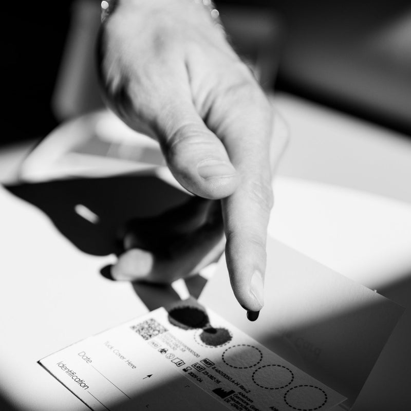 Im Hintergrund sieht man zwei Hände, die ineinandergreifen. Im Vordegrund sind Probenahme-Sets für die Vorsorge von DoctorBox zusehen