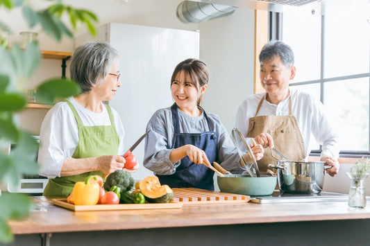 Mutter, Tochter und Vater kochen in der Küche und sind glücklich, dass die reine Hypercholesterinämie Vergangenheit ist.